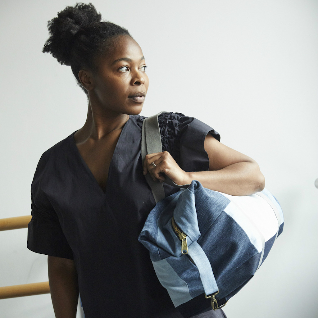 Eine Frau trägt eine blaue Patchwork-Tasche